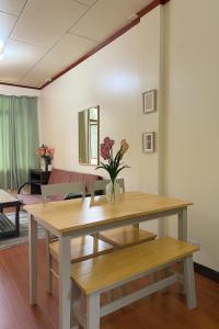 a dining room table with a vase of flowers on it at Audi's Serviced Apartment in Puerto Princesa City