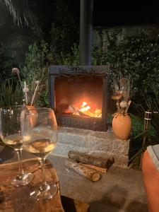 a glass of wine sitting next to a fireplace at Casa en Chuy in Chuy