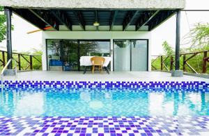 a pool with a table and chairs next to a house at Kitumo Mara Lodges in Mara Simba