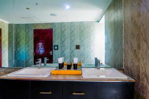 a bathroom with two sinks and a large mirror at Kitumo Mara Lodges in Mara Simba