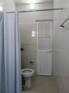a bathroom with a toilet and a shower with a door at Casa Lomalinda in Miahuatlán de Porfirio Díaz +9 photos