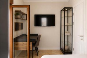 a bedroom with a desk and a tv and a mirror at Villa Jasmine in Kartepe