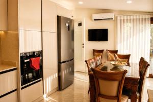 a kitchen and dining room with a table and a refrigerator at Villa Jasmine in Kartepe