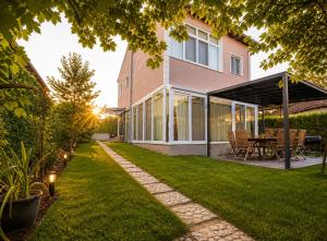 a house with a garden with a table and a patio at Villa Jasmine in Kartepe