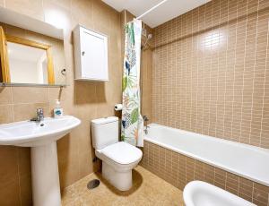 a bathroom with a toilet and a sink and a tub at Brisa del Mar - 2 min playa in El Ejido