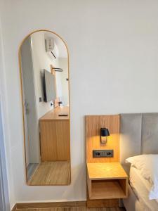 a bedroom with a mirror next to a bed at Hotel Azure in Dhërmi +61 photos