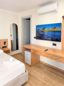 a bedroom with a large tv on the wall at Hotel Azure in Dhërmi