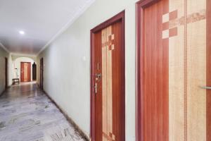a corridor with two wooden doors in a room at Hotel O Aadaab in Hyderabad