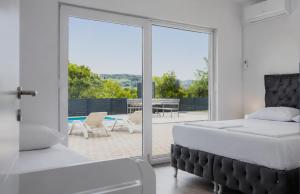 a bedroom with a bed and a view of a patio at Villas Magnolia in Blagaj +67 photos