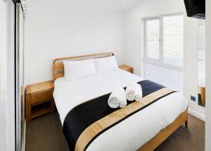 a bedroom with a bed with two towels on it at Foxhunter Park in Kent