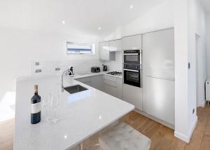 a white kitchen with a bottle of wine on a counter at Foxhunter Park in Kent