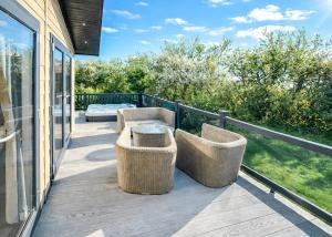 a deck with wicker chairs and a table at Foxhunter Park in Kent