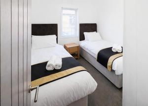 a bedroom with two beds and two slippers at Foxhunter Park in Kent +12 photos