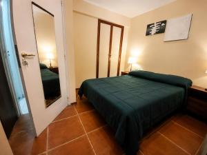 a bedroom with a green bed and a mirror at Depto Termas Centro in Termas de Río Hondo +5 photos