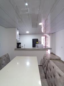 a kitchen with a white table and some chairs at Hospedaje La Tebaida in La Tebaida