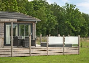 a wooden deck with chairs and a gazebo at Aspen Lodge Escape in Hengrave