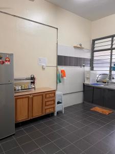 a kitchen with a sink and a refrigerator in a room at Homestay 76 in Mersing