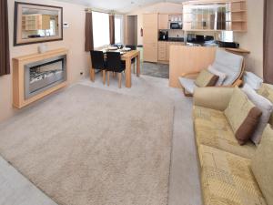 a living room with a couch and a fireplace at Fellside Lodge in Cockermouth