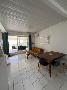 a living room with a table and a couch at La maison sur la plage in Saint-Pierre