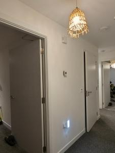 a hallway with a door and a chandelier at Cosy Centre in Dundee