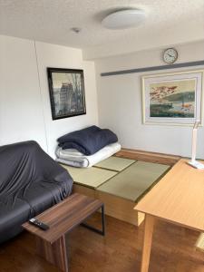a living room with a couch and a bed at Gallery Compass- Art Apartments Osaka with Breakfast Free Parking in Osaka