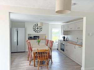 a kitchen with a table and chairs and a refrigerator at High Park House in Brough