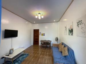 a living room with a blue couch and a table at A-rena Homestay in General Luna