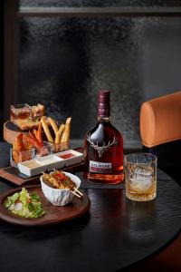 a bottle of whiskey sitting on a table with a plate of food at Prime Hotel Beijing Wangfujing in Beijing