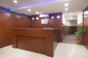 a lobby with a reception desk with clocks on the wall at Shoba Tulip Hebbal in Bengaluru