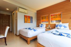una habitación de hotel con 2 camas y una silla en Chaweng Budget Hotel en Chaweng Beach