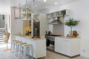 a kitchen with white cabinets and stainless steel appliances at Villa 8 on Murphy Prime Location & Lifestyle in Port Douglas