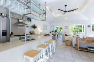 a kitchen and living room with a counter and stools at Villa 8 on Murphy Prime Location & Lifestyle in Port Douglas