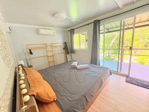 a bedroom with a bed and a large window at Moon Jungle Bungalows in Ban Madua Wan