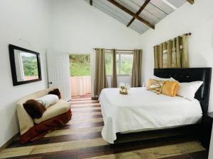 a bedroom with a bed and a chair in it at villa los recuerdos in Jarabacoa