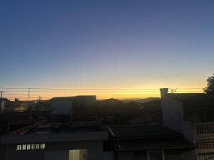 a view of a city with the sunset in the background at D Castro Art House in Montes Claros