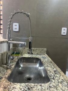 a kitchen sink with a faucet on a counter at D Castro Art House in Montes Claros +13 photos