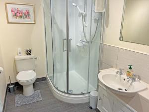 a bathroom with a shower and a toilet and a sink at Belgravia Cottage in Skipton +4 photos