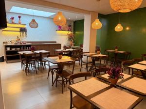 a dining room with tables and chairs in a restaurant at POUSADA MILÊNIO LTDA in Ponte Nova