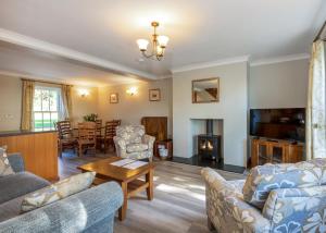 a living room with couches and a table and a fireplace at Green Acres Cottages in Par