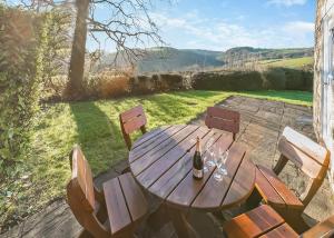 a wooden table with chairs and a bottle of wine at Green Acres Cottages in Par