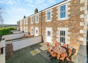 a patio with a table and chairs in front of a building at Green Acres Cottages in Par +13 photos