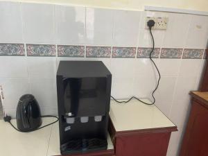 a black microwave sitting on a counter in a kitchen at MY VILLA PD in Port Dickson