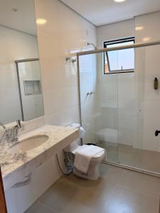 a bathroom with a sink and a toilet and a shower at POUSADA MILÊNIO LTDA in Ponte Nova +14 photos