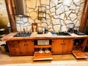a kitchen with a sink and a stone wall at Chalés La Montagna in Santa Teresa