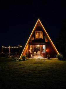 a large wooden cabin with lights in the night at Chalés La Montagna in Santa Teresa