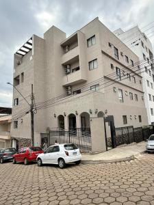 a building with cars parked in front of it at POUSADA MILÊNIO LTDA in Ponte Nova