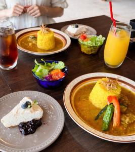 a wooden table topped with plates of food and drinks at Loving Garden Stayラビングガーデンステイ in Mima +26 photos