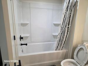 a bathroom with a white tub and a toilet at Executive Luxury Suite Unit B in Regina +16 photos