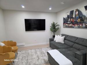a living room with a couch and a flat screen tv at Executive Luxury Suite Unit B in Regina