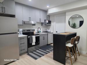 a kitchen with white cabinets and a black counter top at Executive Luxury Suite Unit B in Regina